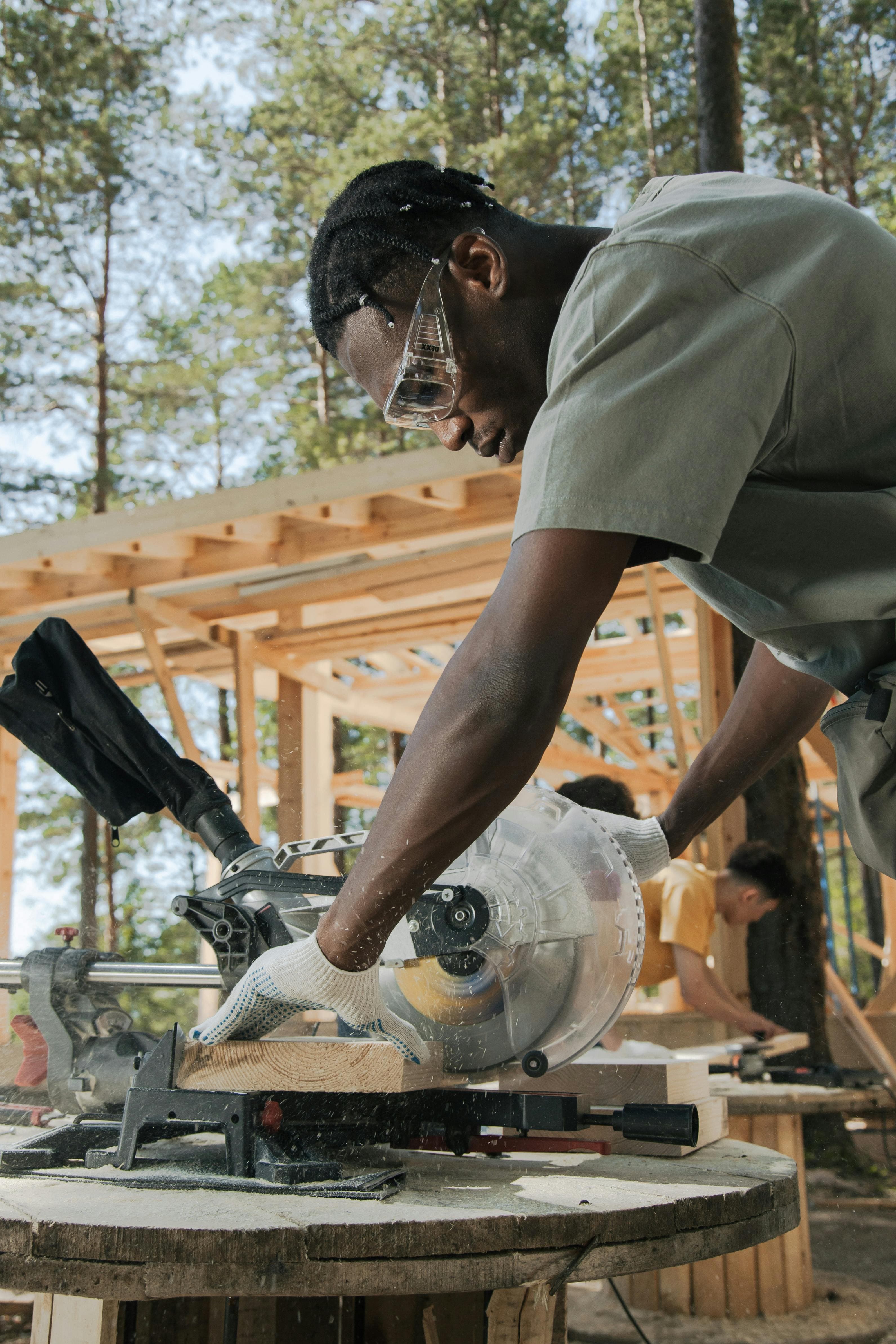 Carpenter cutting wood with a miter saw on a job site